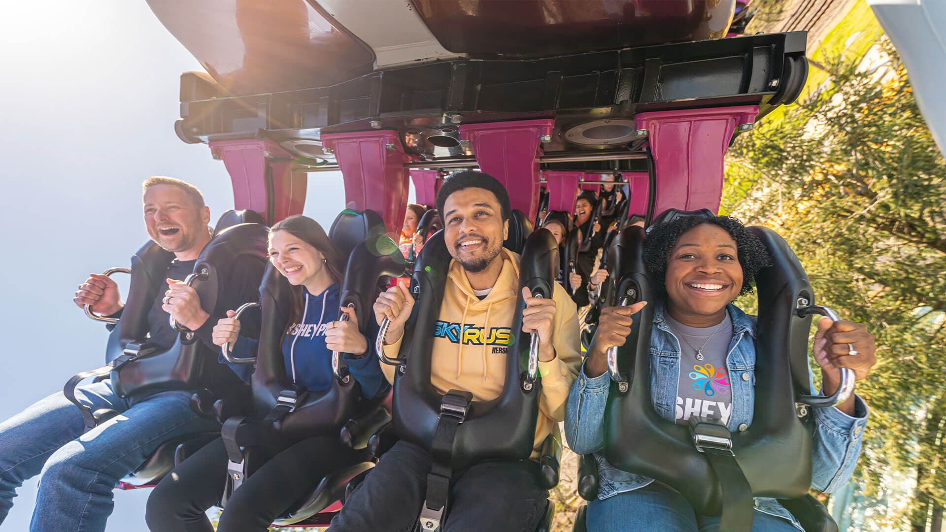 smiling adults and teens on great bear roller coaster hersheypark